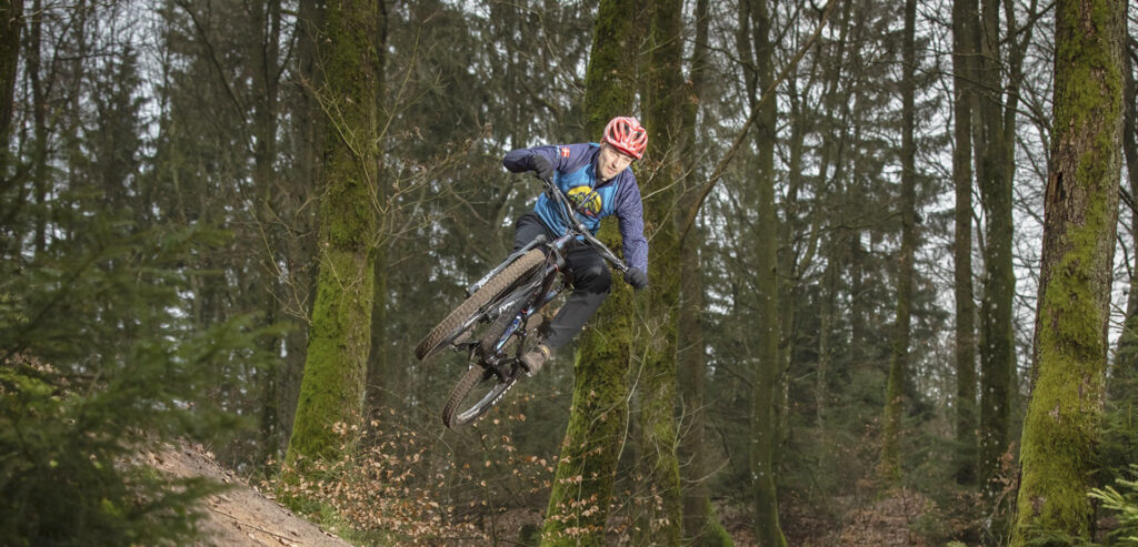 MTB rytter der svæver i luften midt i skoven
