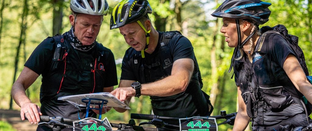 3 mtb cyklister der ser på kort